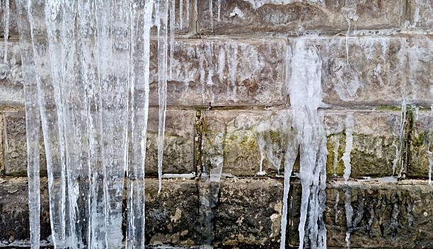 Icicles against a rusticated wall. Urban apocalypse. Selective focus.