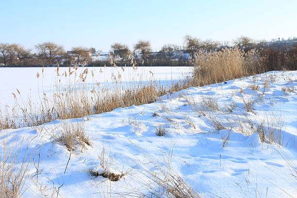 A field of snow. Snow. Outdoor. Sky. Nature. Pond
