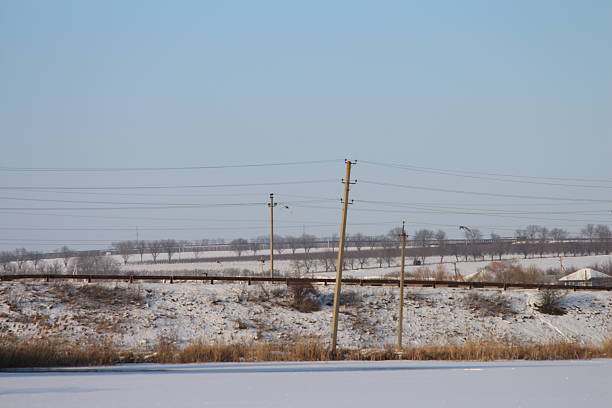A snowy road with power lines. Sky. Outdoor. Day