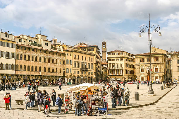 Florence, Italy - 23 March, 2006: People walking in the Piazza della Signoria. The square hosts the the Pallazzo Vecchio, the Fontana del Nettuno and the Loggia dei Signoria.
