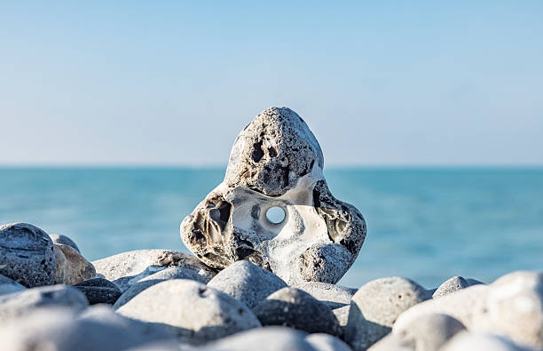 The stones of the pyramid balance on the rock. Sea, time for meditation.