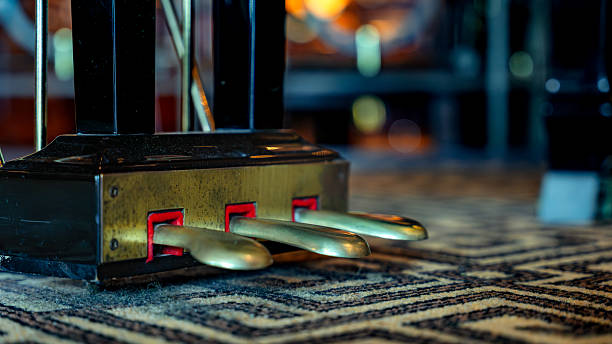 Close-up view showing piano pedals on a patterned carpet floor