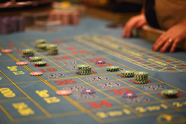Casino felt green table with red and black numbers. Stack of poker chips.