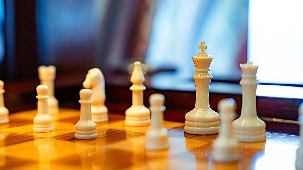 White chess pieces arranged on a wooden board, ready for a strategic game