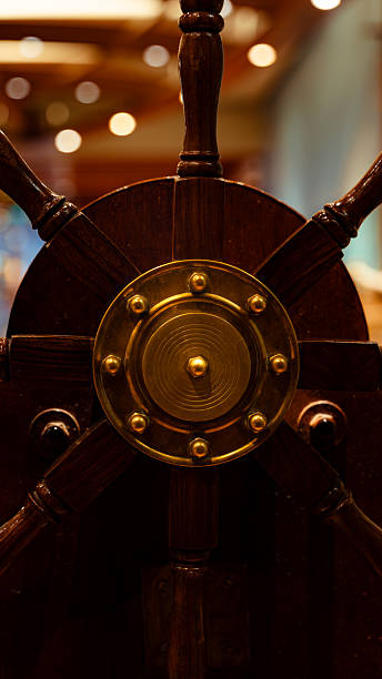 Ship's wheel made of dark wood and brass for maritime navigation