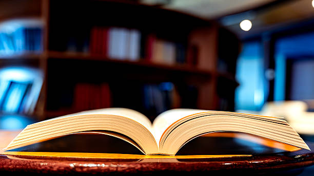 istock Open book resting on table in library studying literature 2256610376