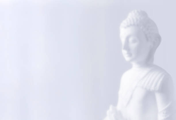 Soft-focus Buddha statue in a minimal light background, creating a calm and meditative atmosphere with copy space