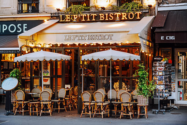 Paris, France: A senior man sits at a traditional French restaurant with a red-and-white checked tablecloth and a bottle of wine in the 9th arrondissement.