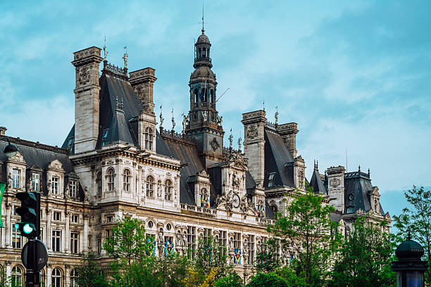 Elegant Paris architectural landmark featuring ornate facades, tall spires, and decorative details. A striking cityscape of classical French design, framed by greenery under a clear blue sky, capturing grandeur and urban history.