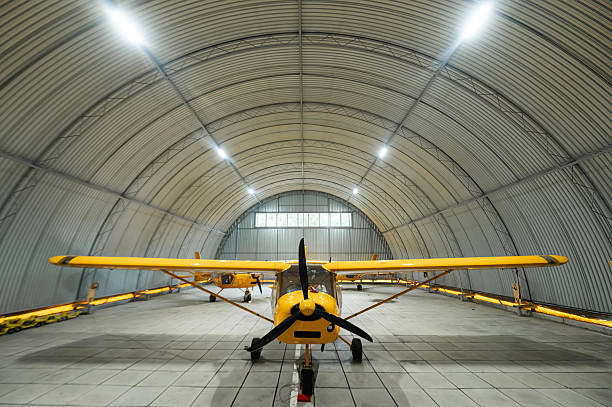Small airplanes parked in a hangar.