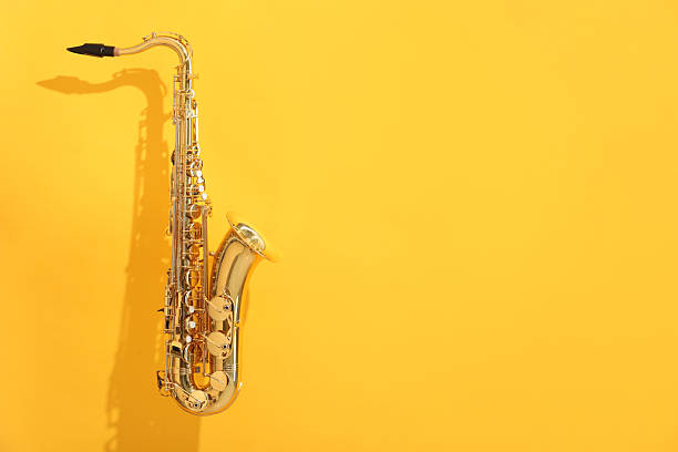 Golden saxophone on yellow background. Space for text