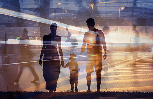 Father, mother and son walking in a busy city.