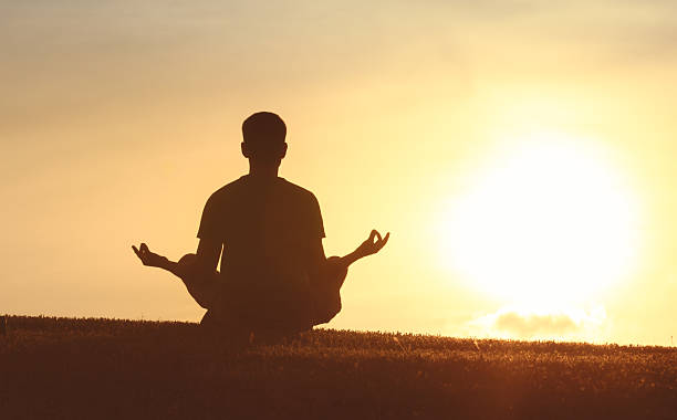 istock Man meditating in a beautiful natural sunset setting. 2256631250