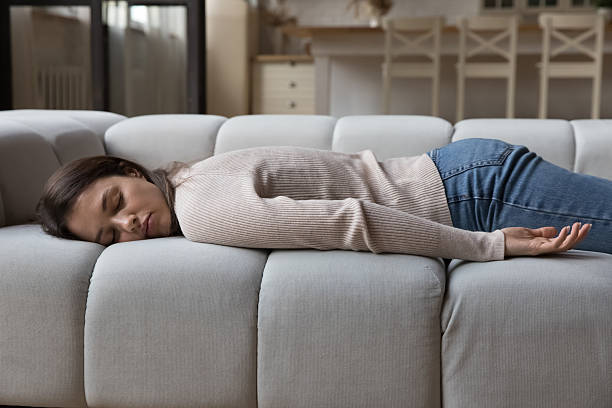 istock Tired woman resting on spacious sofa in home living room 2256641200