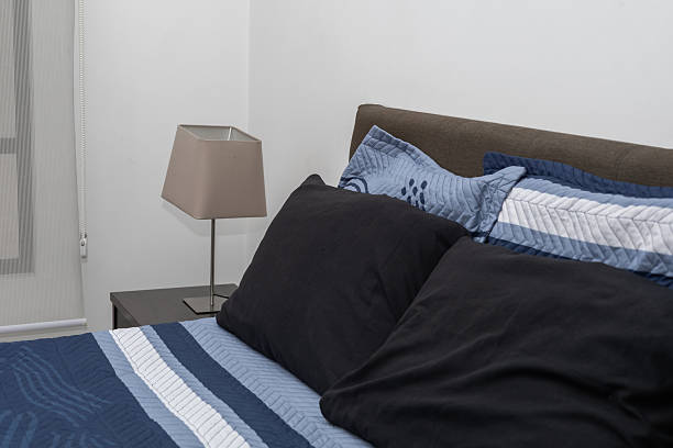 This image shows a black metal bed frame with an ornate headboard, positioned in a modern bedroom setting.