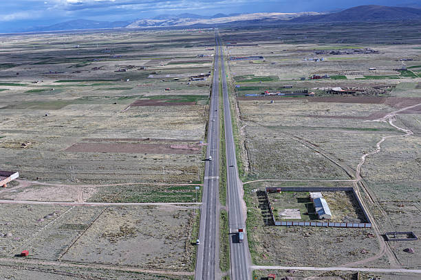 Panoramic view of a straight highway in rural areas next to meadows