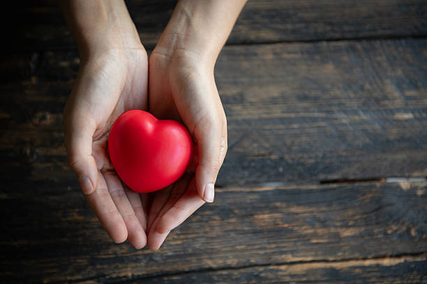 istock Hands Holding Red Heart on Dark Wooden Background 2256658641