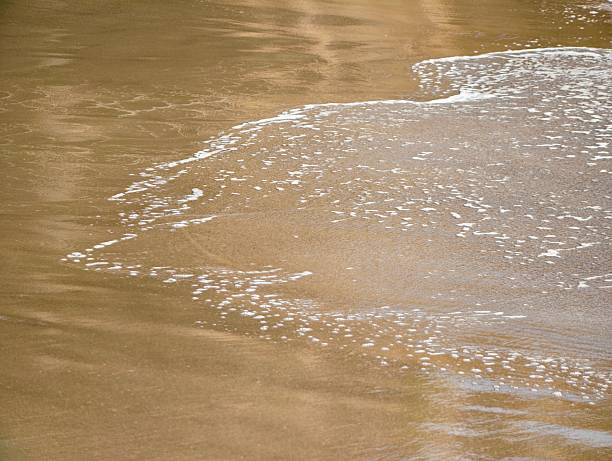 Close up sea waves on the beach at sunset.