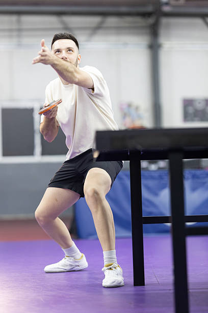 Male athlete concentrating, holding paddle, getting ready for a table tennis serve