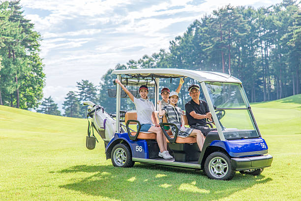 Male and female golfers riding golf carts at a golf course