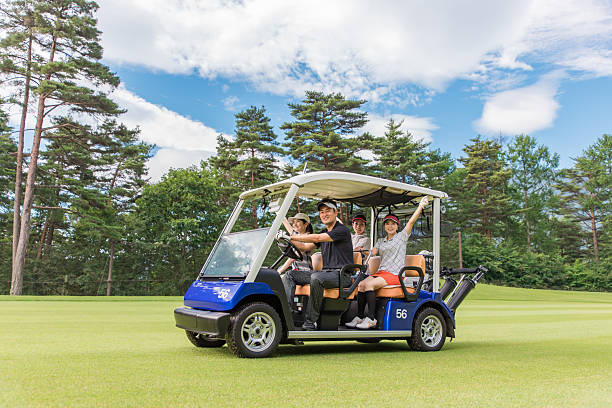 Male and female golfers riding golf carts at a golf course