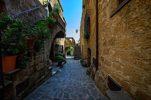 Picturesque medieval-style passageway with stone paving, stairs, and warm sunlight. Authentic old town atmosphere with no people.
