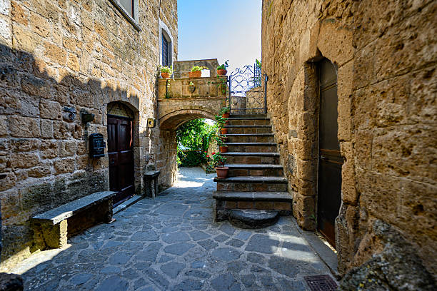 Charming narrow stone alley with stairs and archway in a historic village. Traditional architecture, textured stone walls, and peaceful atmosphere.
