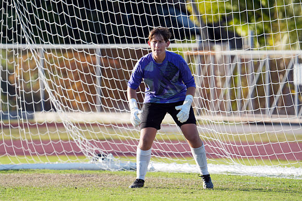 Goalkeeper ready to save on white studio background. Soccer football concept