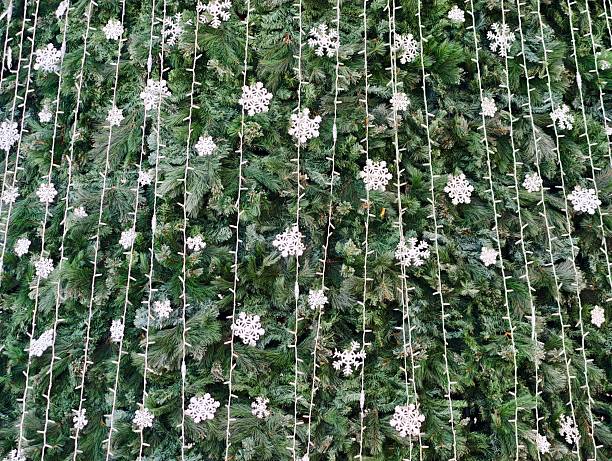 Holiday display featuring lush greenery and shimmering snowflake embellishments arranged in vertical strands