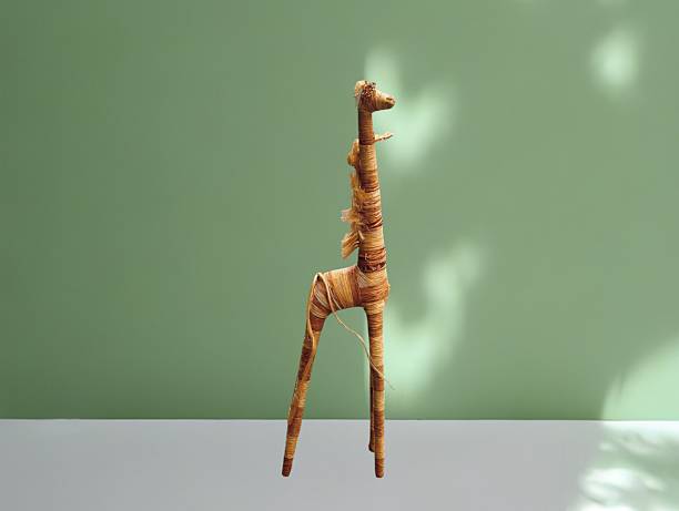 The green background in the image features a brown giraffe made of woven ropes in two colors—light and dark brown—that are interwoven alternately. It has long legs and a long body very beautiful.