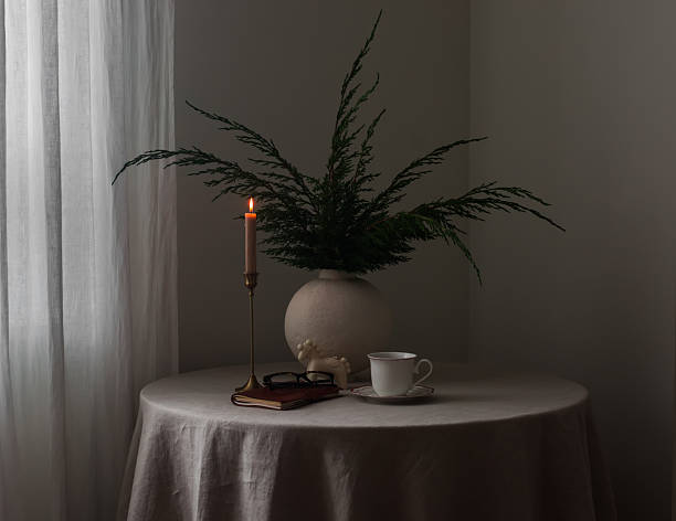 Beige cylindrical podium with draped fabric in moody lighting for product display mockup.