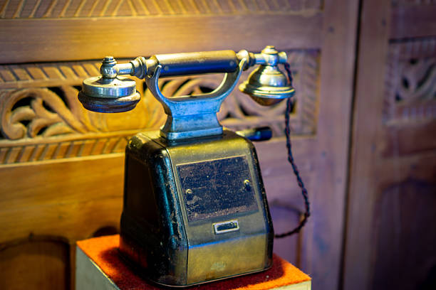 An old brown and black telephone on the table. An ancient communication device.