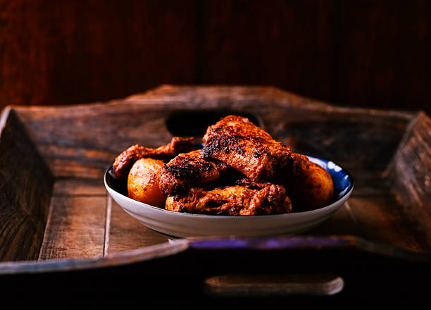 Fried chicken wings with potatoes on a rustic background. Soft focus.