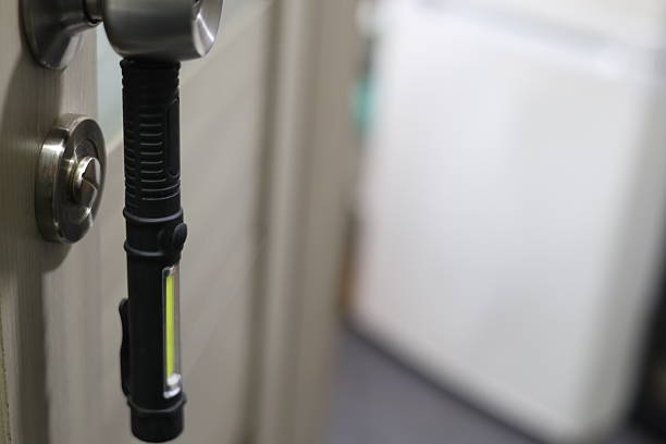 A green and black flashlight with two white lights. High quality photo