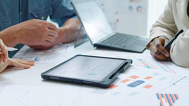 istock Close up Diverse Collaborative Business people meeting with Digital Devices computer brainstorming the financial report paperwork document analyzing data or planning strategies displays a graph or chart in a modern business technology 2256698693