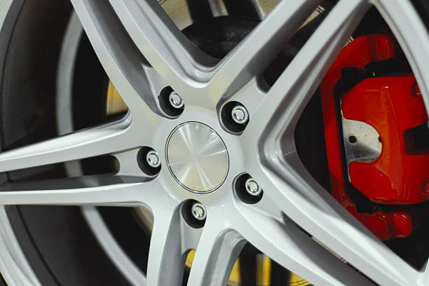 Close-up of a shiny silver alloy wheel featuring multi-spoke design and vibrant red high-performance brake caliper behind black tire