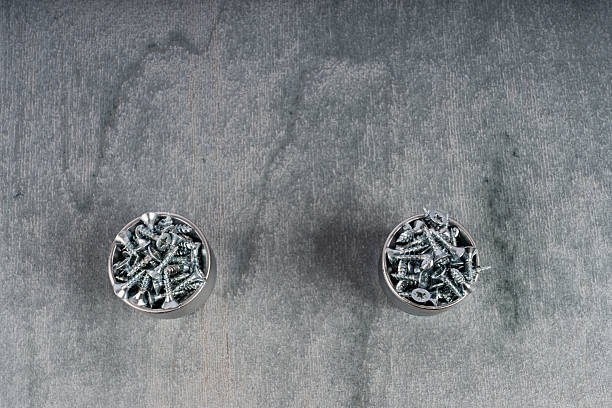 Unique earrings with silver screws on a gray background