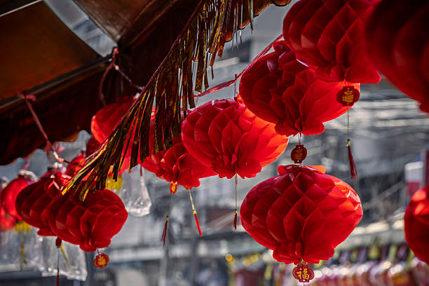 Vibrant red paper lanterns with golden accents adorn an outdoor space, creating a festive atmosphere for Lunar New Year celebrations. They symbolize good fortune and happiness.