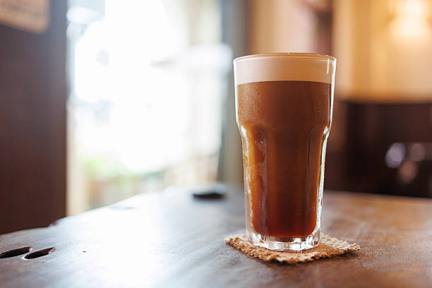 Iced Shaken Robusta Coffee Served in Glass at Cafe Table