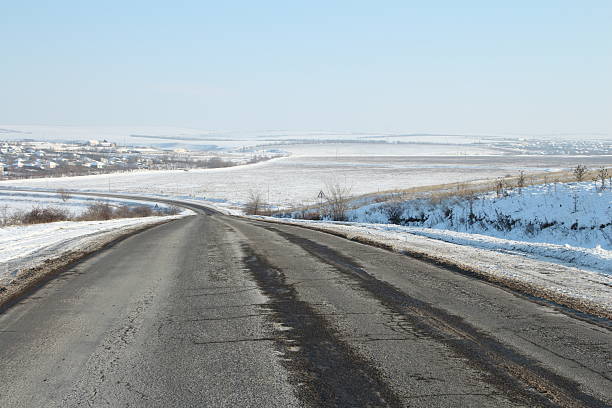 A road with snow on the side. Sky. Outdoor. Scene. Way. Road