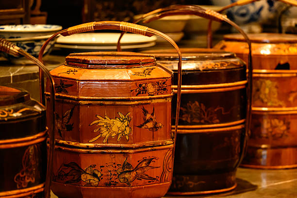An antique airtight wooden food carrier from the Ming or Qing dynasty, intricately lacquered with colorful floral and auspicious motifs, designed for transporting meals with elegance.