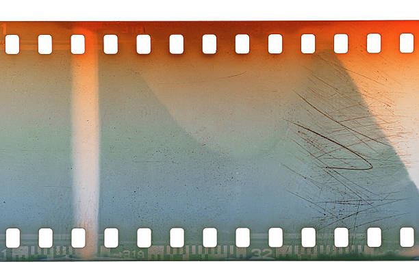 Dusty and grungy 35mm film texture or surface. Perforated scratched camera film isolated on white background.