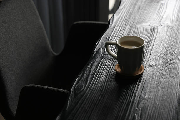 Coffee Break with a Coffee Cup on top of a Black Wood Material Table and Selective Focus