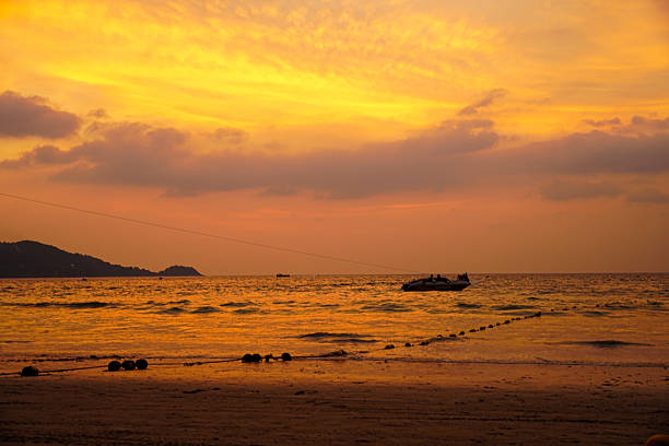 Golden light reflecting across the sea during sunset, emphasizing warm tones and tranquil mood