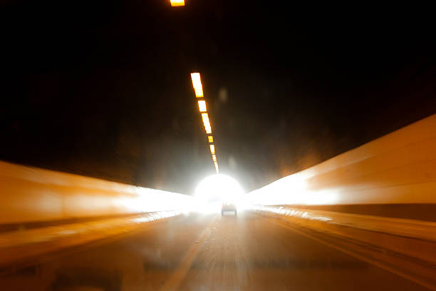 Streams of light flow through a dark road tunnel, capturing a quiet moment of movement and transition. The blurred trails suggest speed, passage of time, and the invisible journeys we take between one place and another, turning an ordinary road into a space of reflection and motion.