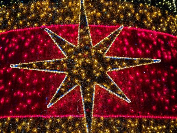 Giant star pattern glowing on dome with dense golden lights, red backdrop, dramatic scale and celebratory