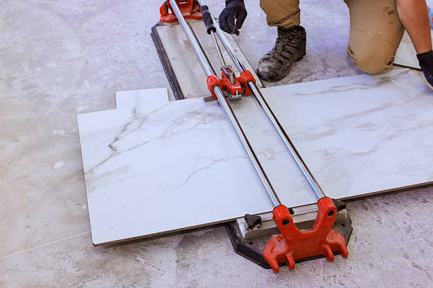 istock Worker uses tile cutter to prepare marble tiles on construction site 2256776960