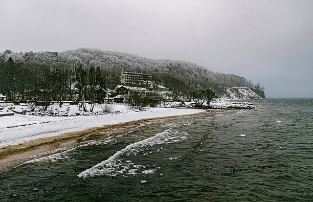 Beautiful winter seascape in Pomerania. Frozen coast of the Baltic Sea and Orlowo cliff in Gdynia. Waves lapping on the shore