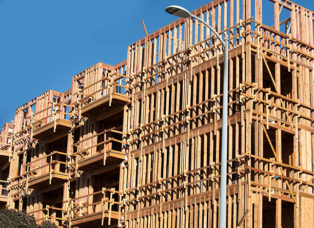 Construction shows wooden framework against blue sky. Construction residential building. Construction reveals structural details as it rises. Construction defines modern development with its frame