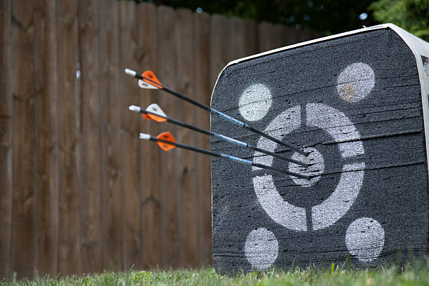 Outdoor Archery target practice with three arrows within the bulleye of a target